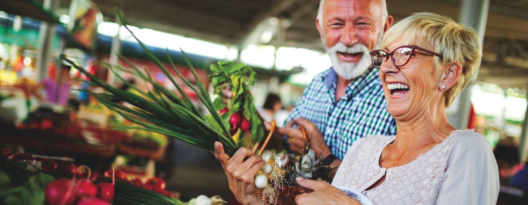 a man and woman holding a basket of vegetables